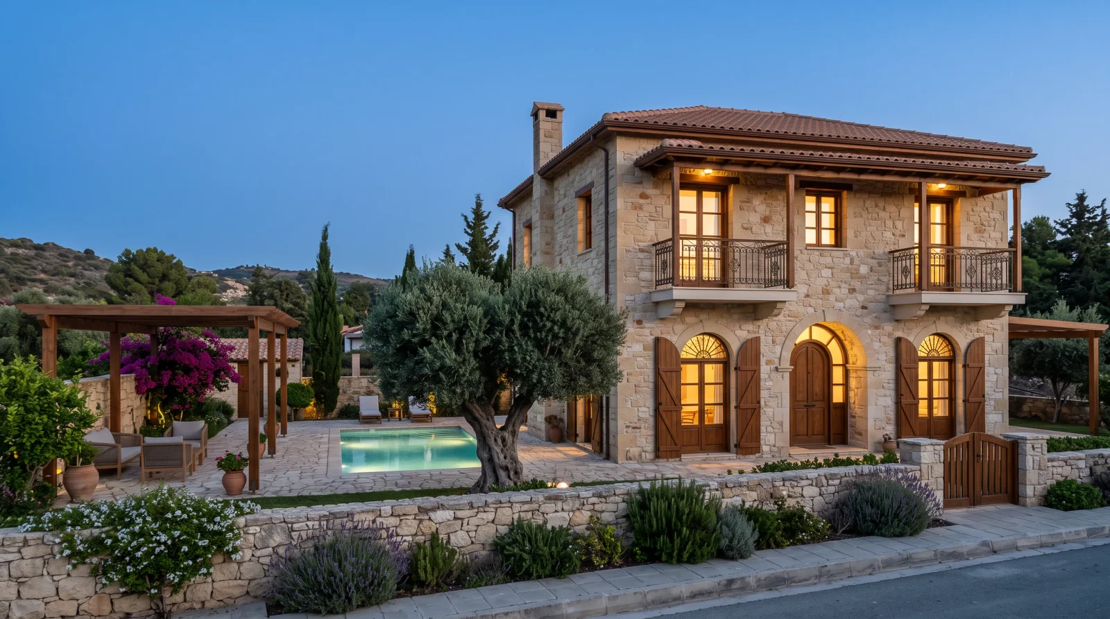 Stone Courtyard Villa — the pergola-shaded courtyard and the arched openings at dusk
